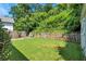 Well-maintained backyard featuring green grass, trees, stone retaining wall, and garden at 2002 Shalimar Ne Dr, Chamblee, GA 30345