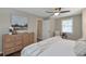 Bright main bedroom with hardwood floors, dresser, art, ceiling fan, and window views at 2002 Shalimar Ne Dr, Chamblee, GA 30345