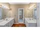 Bathroom featuring double vanities and mirrors, complemented by stylish lighting and tile work at 1219 Hadaway Ct, Lawrenceville, GA 30043