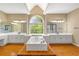 Bathroom with a soaking tub in front of a large window and double vanity sinks at 1219 Hadaway Ct, Lawrenceville, GA 30043