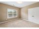 Neutral bedroom with a large window and double-door closet and carpet flooring providing a relaxing space at 1219 Hadaway Ct, Lawrenceville, GA 30043