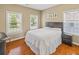 Cozy bedroom with hardwood floors, three windows and a comfortable bed and a night stand at 1219 Hadaway Ct, Lawrenceville, GA 30043