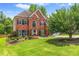 Stately brick home featuring lush green lawn, mature shade trees, and manicured landscaping at 1219 Hadaway Ct, Lawrenceville, GA 30043