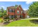Elegant brick home with lush landscaping, mature trees, and an expansive green lawn at 1219 Hadaway Ct, Lawrenceville, GA 30043