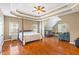 Spacious main bedroom featuring a four-poster bed, a ceiling fan, and a sitting area at 1219 Hadaway Ct, Lawrenceville, GA 30043