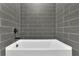 Close up of a tub and tiled walls at 153 Alaina Rd, Holly Springs, GA 30115