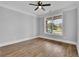 Bright bedroom with wood floors, ceiling fan, and large window overlooking the front yard at 153 Alaina Rd, Holly Springs, GA 30115