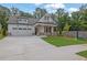 Charming two-story home featuring a manicured lawn, craftsman architecture, and a two-car garage at 153 Alaina Rd, Holly Springs, GA 30115