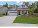 Charming two-story home featuring a well-manicured lawn and a welcoming front porch at 153 Alaina Rd, Holly Springs, GA 30115