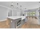Kitchen island with farmhouse sink, stainless steel appliances, open to the living room at 153 Alaina Rd, Holly Springs, GA 30115
