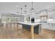 Modern kitchen with a large island, white cabinetry, stainless steel appliances, and pendant lighting at 153 Alaina Rd, Holly Springs, GA 30115