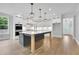 Modern kitchen with a large island, white cabinetry, stainless steel appliances, and pendant lighting at 153 Alaina Rd, Holly Springs, GA 30115