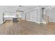 Open floor plan showing kitchen island, cabinets, stainless appliances, and wood floors at 153 Alaina Rd, Holly Springs, GA 30115