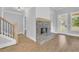 Living room featuring a cozy fireplace with wood trim, stairs and hardwood floors at 153 Alaina Rd, Holly Springs, GA 30115
