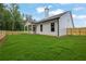 Back of home shows covered patio and lush lawn, perfect for outdoor enjoyment at 153 Alaina Rd, Holly Springs, GA 30115