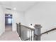 Upstairs hallway with dark metal railing, wood banister, and carpet at 1958 Dillon Dr, Lithonia, GA 30058