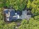 An aerial view shows the house with a spacious driveway, gray roof, and surrounded by green trees at 207 E Hightower E Trl, Social Circle, GA 30025