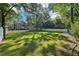 Lovely backyard with a lush green lawn, mature trees, a fence, and a detached garage at 207 E Hightower E Trl, Social Circle, GA 30025
