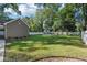 Expansive backyard with lush green grass, a shed, and a well-maintained white picket fence at 207 E Hightower E Trl, Social Circle, GA 30025