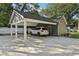 Attached carport offering covered parking, featuring elegant white columns and ample space for vehicle at 207 E Hightower E Trl, Social Circle, GA 30025