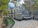 A grand home with light gray siding shows mature landscaping, manicured lawn, and a porte cochere at 207 E Hightower E Trl, Social Circle, GA 30025