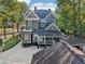 A three-story home shows light gray siding, two chimneys, black trim and a white-columned front porch at 207 E Hightower E Trl, Social Circle, GA 30025