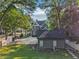 A gray three-story home shows mature landscaping and a rear workshop; perfect for work or hobbies at 207 E Hightower E Trl, Social Circle, GA 30025