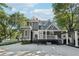 Beautiful two-story home showcasing gray siding, a welcoming front porch, and mature landscaping in the yard at 207 E Hightower E Trl, Social Circle, GA 30025