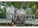 Charming two-story home featuring a covered front porch and a white picket fence at 207 E Hightower E Trl, Social Circle, GA 30025