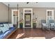 Inviting front porch with a porch swing, rocking chairs, and potted flowers, creating a cozy entrance at 207 E Hightower E Trl, Social Circle, GA 30025