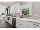 Bright kitchen featuring farmhouse sink, white cabinetry, stainless appliances, and quartz countertops at 207 E Hightower E Trl, Social Circle, GA 30025