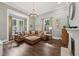 Cozy living room featuring hardwood floors, large windows, and a comfortable leather sectional at 207 E Hightower E Trl, Social Circle, GA 30025