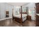 Spacious bedroom with hardwood floors, chandelier, and four poster bed at 207 E Hightower E Trl, Social Circle, GA 30025