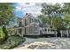 A gray two-story house featuring a covered porch and a large driveway surrounded by green landscaping at 207 E Hightower E Trl, Social Circle, GA 30025