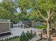 A rear view shows a car port, workshop, large driveway and well-kept lawn with mature trees at 207 E Hightower E Trl, Social Circle, GA 30025