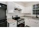 Close-up of a kitchen with white cabinets, granite countertops, and stainless steel appliances at 2864 Parkway Close, Lithonia, GA 30058