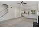 Open living space with neutral carpet, access to a staircase, and a view into a bright kitchen at 2864 Parkway Close, Lithonia, GA 30058