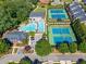 Aerial view of a community pool and tennis courts surrounded by lush landscaping and residential buildings at 3502 Village Green Dr, Roswell, GA 30075
