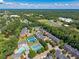 Community aerial view with a pool, tennis courts, and a pond near a school with sports fields at 3502 Village Green Dr, Roswell, GA 30075