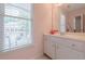 Bright bathroom with a white vanity, large mirror, and a window that lets in natural light at 3502 Village Green Dr, Roswell, GA 30075