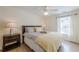 Cozy bedroom with a ceiling fan, wood floors, and a bright window overlooking the yard at 3502 Village Green Dr, Roswell, GA 30075
