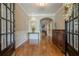 Elegant foyer boasts hardwood floors, detailed trim, and an arched doorway leading to a cozy living space with a fireplace at 3502 Village Green Dr, Roswell, GA 30075