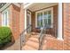 Inviting brick porch with a seating area, perfect for enjoying the outdoors in a charming setting at 3502 Village Green Dr, Roswell, GA 30075