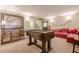Finished game room features foosball table, large artwork and comfy red leather sofa at 3502 Village Green Dr, Roswell, GA 30075
