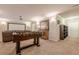 Spacious finished game room with foosball table, media screen, and storage cabinet at 3502 Village Green Dr, Roswell, GA 30075