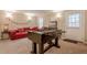 Fun finished game room with foosball table and comfortable red leather seating for entertaining at 3502 Village Green Dr, Roswell, GA 30075