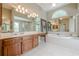 Spacious main bathroom with double vanity, large tub, walk-in shower, and decorative mirrors at 3502 Village Green Dr, Roswell, GA 30075