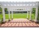 View from under a white pergola overlooking a green lawn in a residential area at 3502 Village Green Dr, Roswell, GA 30075