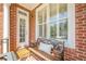 Charming porch featuring a bench with a pillow, a door, and large windows, perfect for relaxing at 3502 Village Green Dr, Roswell, GA 30075