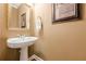 Modern powder room features a pedestal sink, decorative mirror, and elegant wall decor at 3502 Village Green Dr, Roswell, GA 30075